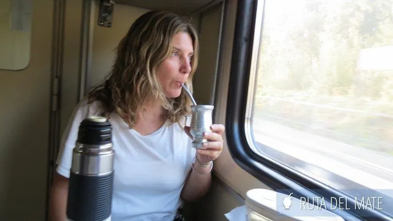 Flor toma mate mirando por la ventanilla de un tren