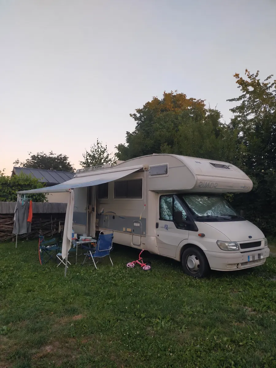 La Matera estacionada en un camping, con el toldo abierto y las sillas afuera